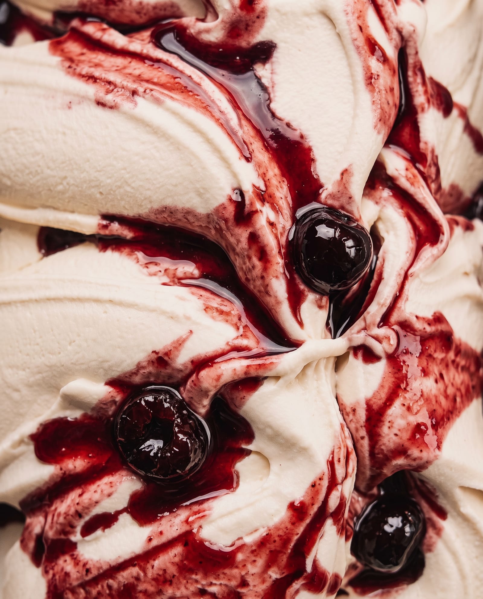 Close-up: wit ijs met swirls van donkerrode Fabbri-amarenasiroop en amarenakersen