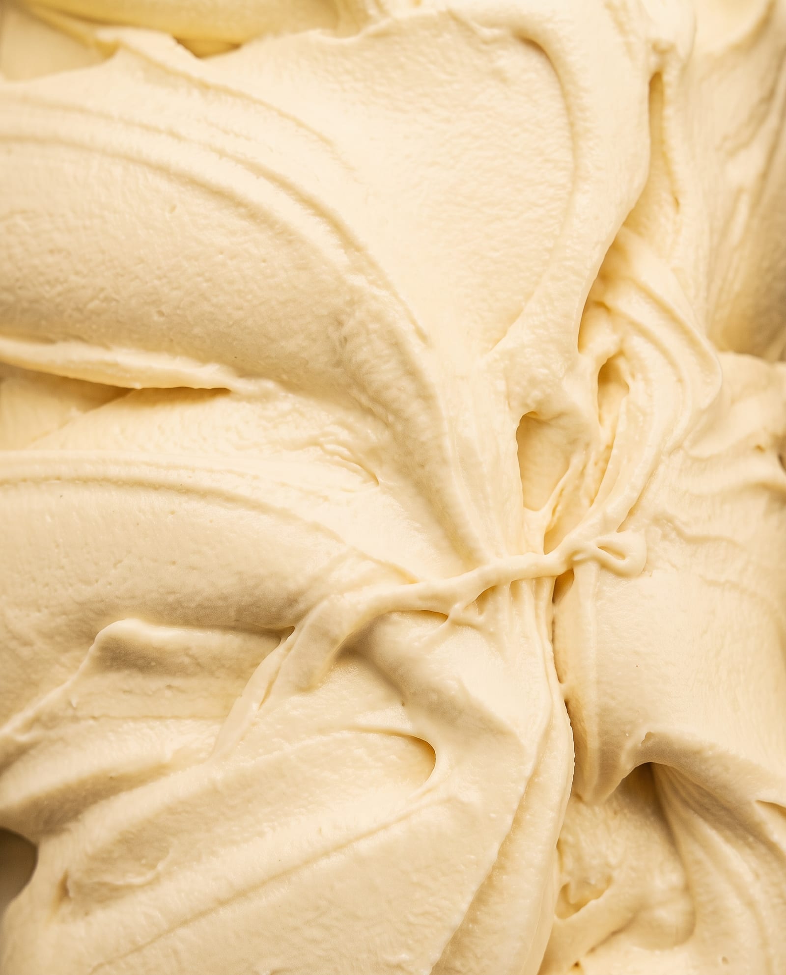 Close-up: effen, lichtgeel bananenijs in zachte swirls, net iets geler dan vanille