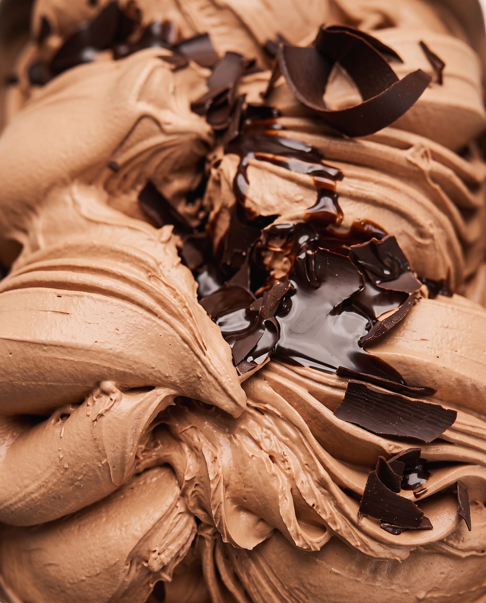 Close-up: melkchocolade-ijs met chocoladekrullen en glanzende chocoladesaus