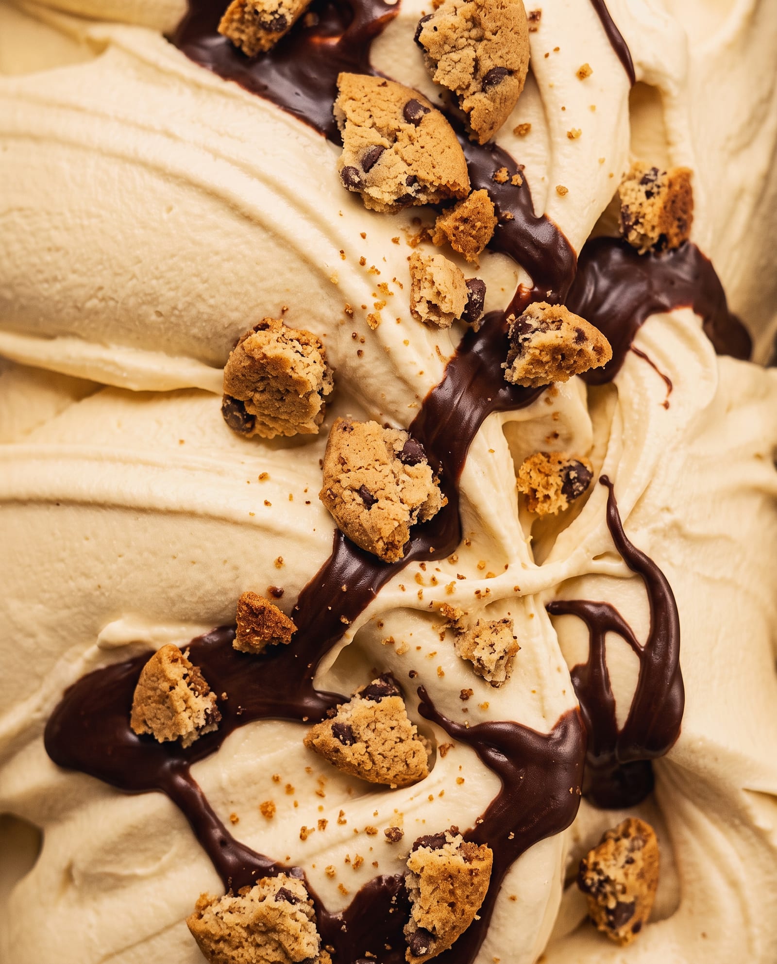 Close-up: geel ijs met een chocoladeswirl en stukjes American cookie