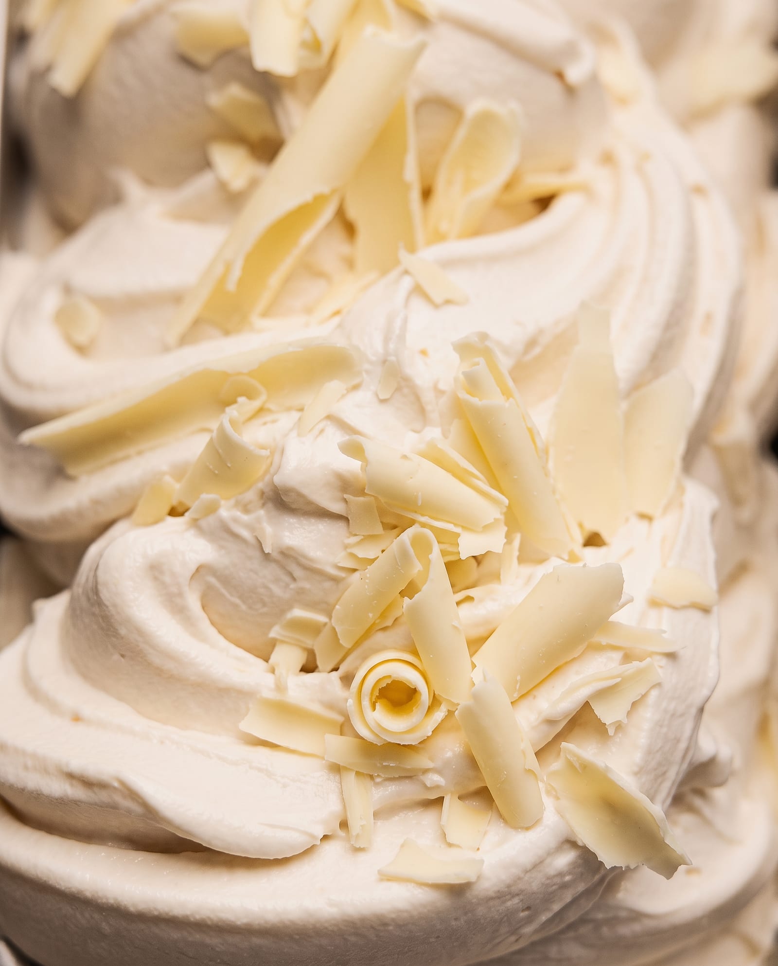 Close-up: ivoorwit witte-chocolade-ijs met krullen witte chocolade